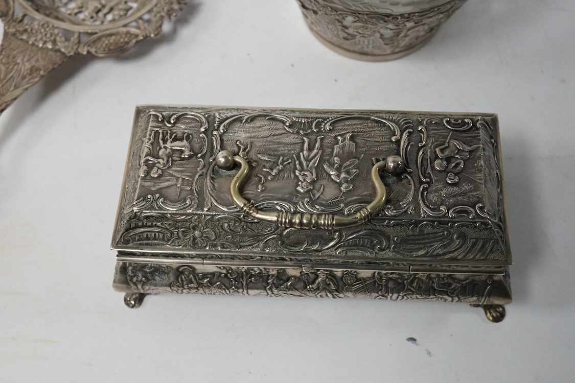A late 19th century German pierced 800 standard white metal mounted liqueur jug, stamped Kremos, 14.4cm, a 19th century Dutch embossed 830 standard white metal trinket box and an Edwardian Hanau silver tea strainer, impo